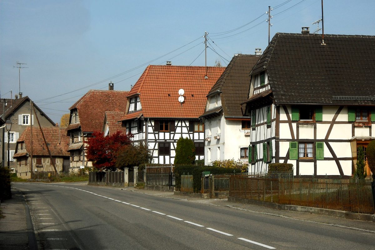 Maisons alsaciennes à colombages le long d'une route de village du Sundgau, dans le sud du Haut-Rhin