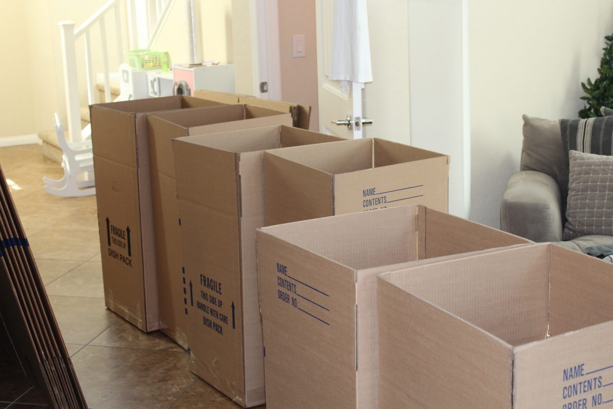 Cartons de déménagement de différentes tailles ouverts dans un logement